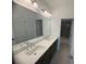 Bathroom boasts a double sink vanity with modern fixtures, and a view of the adjacent bathtub at 707 Dodd N Ln # 164, Buford, GA 30518