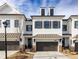 Charming two-story townhome boasts a painted brick facade, dark window shutters, and attached garage at 707 Dodd N Ln # 164, Buford, GA 30518