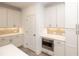 Bright kitchen with white cabinets, stainless steel appliances, built-in microwave, and access to a pantry or storage area at 707 Dodd N Ln # 164, Buford, GA 30518