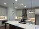 The well-lit kitchen features a center island, stainless steel appliances, and modern pendant lighting at 707 Dodd N Ln # 164, Buford, GA 30518