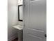 Tastefully designed powder room with a pedestal sink, framed mirror and white door at 707 Dodd N Ln # 164, Buford, GA 30518