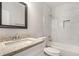 Bright bathroom featuring a granite countertop, sleek vanity, and a shower with white tiled walls at 763 Jones Nw Ave, Atlanta, GA 30314