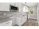 Modern kitchen with white cabinets, stainless steel appliances, granite countertops, and a stylish backsplash at 763 Jones Nw Ave, Atlanta, GA 30314