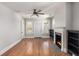 Inviting living room featuring hardwood floors, a cozy fireplace, ceiling fan, and natural light from the windows at 763 Jones Nw Ave, Atlanta, GA 30314