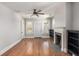 Inviting living room featuring hardwood floors, a cozy fireplace, ceiling fan, and natural light from the windows at 763 Jones Nw Ave, Atlanta, GA 30314