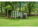A quaint outbuilding provides extra storage space surrounded by greenery in the backyard at 789 Concord Sw Rd, Smyrna, GA 30082