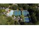 Aerial view of community amenities including a pool and tennis courts surrounded by mature trees at 385 Guildhall Grv, Johns Creek, GA 30022