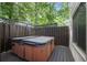 Relax and enjoy the private hot tub surrounded by a wood fence and mature trees at 385 Guildhall Grv, Johns Creek, GA 30022