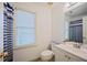 Bright bathroom features a white vanity, toilet, and blue-striped shower curtain at 385 Guildhall Grv, Johns Creek, GA 30022