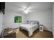 Well-lit bedroom featuring a queen bed, bedside table, and a large window at 385 Guildhall Grv, Johns Creek, GA 30022