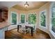 Bright breakfast nook with bay windows overlooking lush greenery and hardwood flooring at 385 Guildhall Grv, Johns Creek, GA 30022