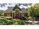 A beautifully landscaped brick clubhouse with a grand arched entrance at 385 Guildhall Grv, Johns Creek, GA 30022