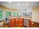 Kitchen island with stainless steel dishwasher and sink, opening to a bright breakfast area at 385 Guildhall Grv, Johns Creek, GA 30022
