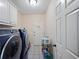 Convenient laundry room with washer, dryer, storage cabinets, and outdoor access at 385 Guildhall Grv, Johns Creek, GA 30022