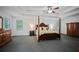 Spacious primary bedroom featuring a four-poster bed, neutral walls, and a ceiling fan at 385 Guildhall Grv, Johns Creek, GA 30022