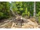 An outdoor patio with stone flooring surrounded by lush greenery at 385 Guildhall Grv, Johns Creek, GA 30022