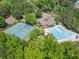 Aerial view of the swimming pool and tennis courts nestled between mature trees at 813 Cotton Creek Dr, Canton, GA 30115