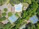 Aerial view of a community pool, tennis courts and playground surrounded by mature trees at 813 Cotton Creek Dr, Canton, GA 30115
