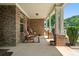Inviting covered porch with rocking chairs and brick pillars, perfect for relaxing at 813 Cotton Creek Dr, Canton, GA 30115