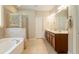 Main bathroom with double vanity, soaking tub, separate glass shower, and neutral tile at 813 Cotton Creek Dr, Canton, GA 30115