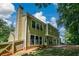 This home features a large backyard with a patio area and a tall chimney under a partly cloudy sky at 9050 Brockham Way, Alpharetta, GA 30022