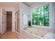 This spa-like bathroom features a walk-in shower and a jetted soaking tub set under a window at 9050 Brockham Way, Alpharetta, GA 30022