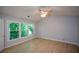 Vaulted bedroom featuring hardwood floors, a ceiling fan, and large windows showcasing backyard trees at 9050 Brockham Way, Alpharetta, GA 30022