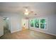 Vaulted bedroom with hardwood floors, ceiling fan, and windows overlooking backyard trees, plus bath access at 9050 Brockham Way, Alpharetta, GA 30022
