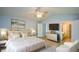 This primary bedroom features an ensuite bathroom, sitting area, fan, and stylish decorations at 9050 Brockham Way, Alpharetta, GA 30022