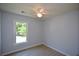 A bedroom features light grey walls, a ceiling fan, luxury vinyl plank floors, and a window at 9050 Brockham Way, Alpharetta, GA 30022