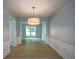 Dining room with modern chandelier, wood-look floors, and access to other rooms at 9050 Brockham Way, Alpharetta, GA 30022