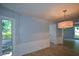 A dining room featuring wood flooring, modern wainscoting, a light fixture, and a view of the backyard at 9050 Brockham Way, Alpharetta, GA 30022