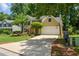 Inviting home features a large driveway, mature landscaping, and an attached two-car garage at 9050 Brockham Way, Alpharetta, GA 30022