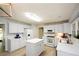 Bright kitchen features white cabinetry, stainless steel sink, and center island at 9050 Brockham Way, Alpharetta, GA 30022