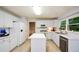 Bright kitchen features white cabinetry, stainless steel sink, and center island at 9050 Brockham Way, Alpharetta, GA 30022