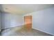 Neutral living room with wood-look floors, light paint, and open doorway into another space at 9050 Brockham Way, Alpharetta, GA 30022