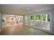 Bright living room with hardwood floors, large windows, and an open view to the modern, white kitchen at 9050 Brockham Way, Alpharetta, GA 30022
