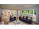 Comfortable living room featuring a stylish sofa, hardwood floors, and view of modern kitchen and backyard at 9050 Brockham Way, Alpharetta, GA 30022