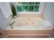 A soaking tub is set under a window and features clean white towels at 9050 Brockham Way, Alpharetta, GA 30022