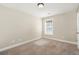 A cozy bedroom featuring neutral paint, carpet and a window at 5712 Grande River Rd, Atlanta, GA 30349