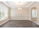 Bright dining room with large windows, hardwood floors and a modern chandelier at 5712 Grande River Rd, Atlanta, GA 30349