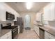 Modern kitchen features granite countertops, stainless steel appliances, white cabinets, and tiled backsplash at 5712 Grande River Rd, Atlanta, GA 30349