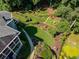 An aerial view of the landscaped backyard shows stone paths, manicured lawns, and established trees with privacy at 710 Bentgrass Ct, Dacula, GA 30019