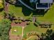 Aerial view showcases a professionally landscaped backyard with manicured lawns, stone paths, and mature trees at 710 Bentgrass Ct, Dacula, GA 30019