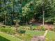 Large manicured backyard featuring beautiful landscaping and unique metal decorative art at 710 Bentgrass Ct, Dacula, GA 30019