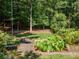 A lush backyard featuring a small bridge and abundant foliage surrounded by mature trees providing privacy at 710 Bentgrass Ct, Dacula, GA 30019