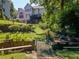 Multi-level backyard featuring a stone bridge, lush foliage, and a view of the deck and home exterior at 710 Bentgrass Ct, Dacula, GA 30019