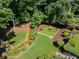 Landscaped backyard featuring lush greenery, a small stream, and a cozy outdoor seating area at 710 Bentgrass Ct, Dacula, GA 30019
