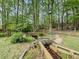 The charming backyard features a decorative stream with a bridge, surrounded by mature trees at 710 Bentgrass Ct, Dacula, GA 30019
