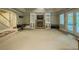 Finished basement with stone fireplace, built-in shelves, french doors, and carpeted floor at 710 Bentgrass Ct, Dacula, GA 30019